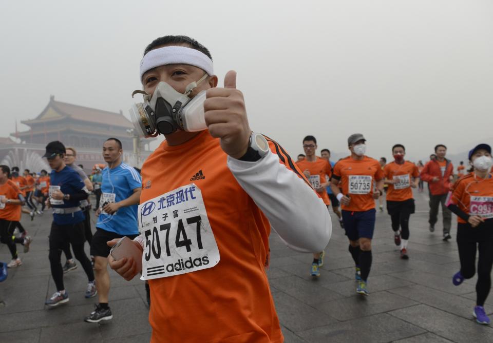 Participants wearing masks during a hazy day at the Beijing International Marathon in front of Tiananmen Square, in Beijing