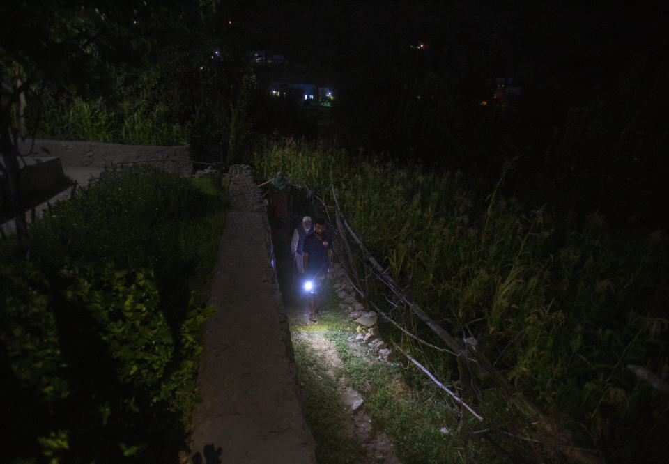 Mohammad Younis and his relative Lal use a torch from a mobile phone as they walk outside their home at Dardkhor village, an area that experiences frequent attacks from wild animals, on the outskirts of Srinagar, Indian controlled Kashmir, Monday, Aug. 24, 2020. Amid the long-raging deadly strife in Indian-controlled Kashmir, another conflict is silently taking its toll on the Himalayan region’s residents: the conflict between man and wild animals. According to official data, at least 67 people have been killed and 940 others injured in the past five years in attacks by wild animals in the famed Kashmir Valley, a vast collection of alpine forests, connected wetlands and waterways known as much for its idyllic vistas as for its decades-long armed conflict between Indian troops and rebels. (AP Photo/Mukhtar Khan)