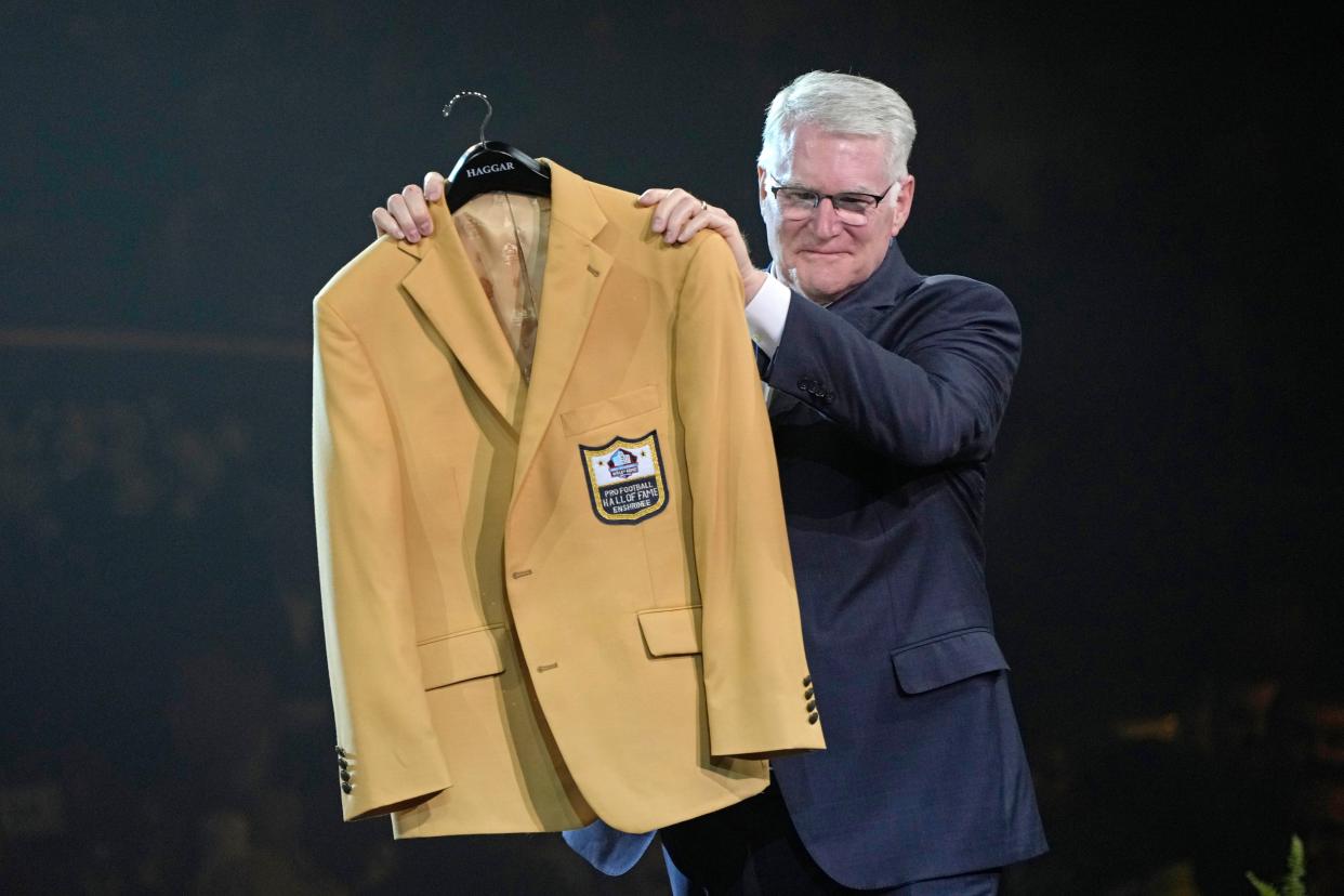 Scott Howley, son of Chuck Howley, a member of the Pro Football Hall of Fame Class of 2023, receives his father's jacket Friday in Canton.