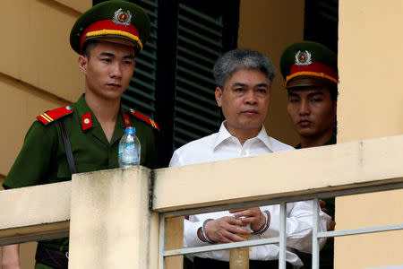 Former Petro Vietnam (PVN) chairman Nguyen Xuan Son (C) is escorted by police while he leaves the court after the verdict session in Hanoi, Vietnam September 29, 2017. REUTERS/Kham