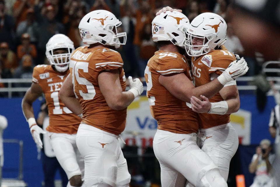 Texas quarterback Sam Ehlinger (11) celebrates his touchdown run against Utah with teammates during the second half of the Alamo Bowl NCAA college football game in San Antonio, Tuesday, Dec. 31, 2019. (AP Photo/Eric Gay)