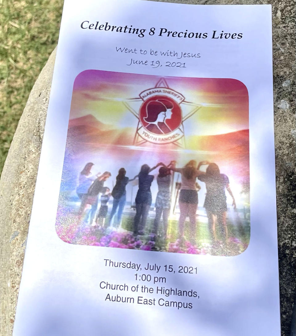 The program for a memorial service for eight young people, killed when a van returning to an Alabama girls home after a week at the beach wrecked last month, is shown outside the event on Thursday, July 15, 2021, in Auburn, Ala. Two other people died in a separate vehicle in the crash, which happened as Tropical Storm Claudette moved through the Southeast. (AP Photo/Kim Chandler)