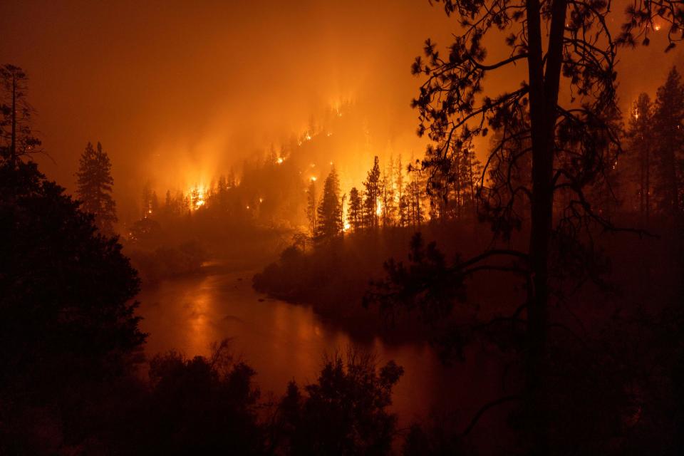 July 31, 2022: Flames burn near the Klamath River during the McKinney Fire in the Klamath National Forest northwest of Yreka, Calif.  The largest fire in California this year is forcing thousands of people to evacuate as it destroys homes and rips through the state's dry terrain, whipped up by strong winds and lightning storms.