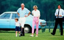 <p>The Princess of Wales strolls the lawns of Windsor with a young Prince William and Major Ronald Ferguson during a summer polo match at Guards Polo Club. </p>