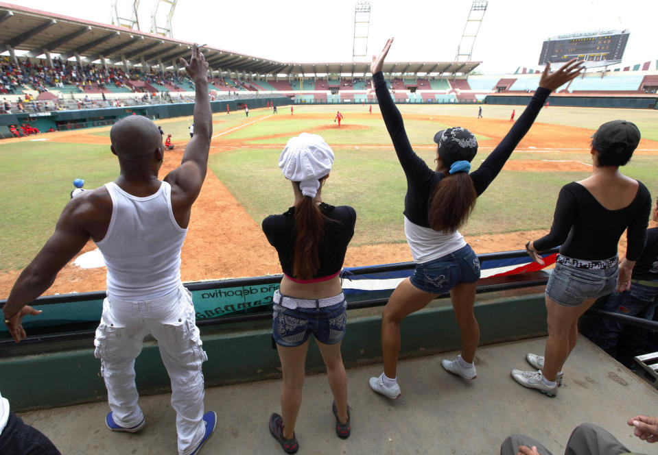 In this picture taken Sunday April 22, 2012, young men and women dance in the front row during the Cuban National Baseball Series between the Holguin home team and the Havana-based Metropolitanos, a farm team of the better-known Industriales at the local stadium in Holguin, Cuba. (AP Photo/Kathy Willens)