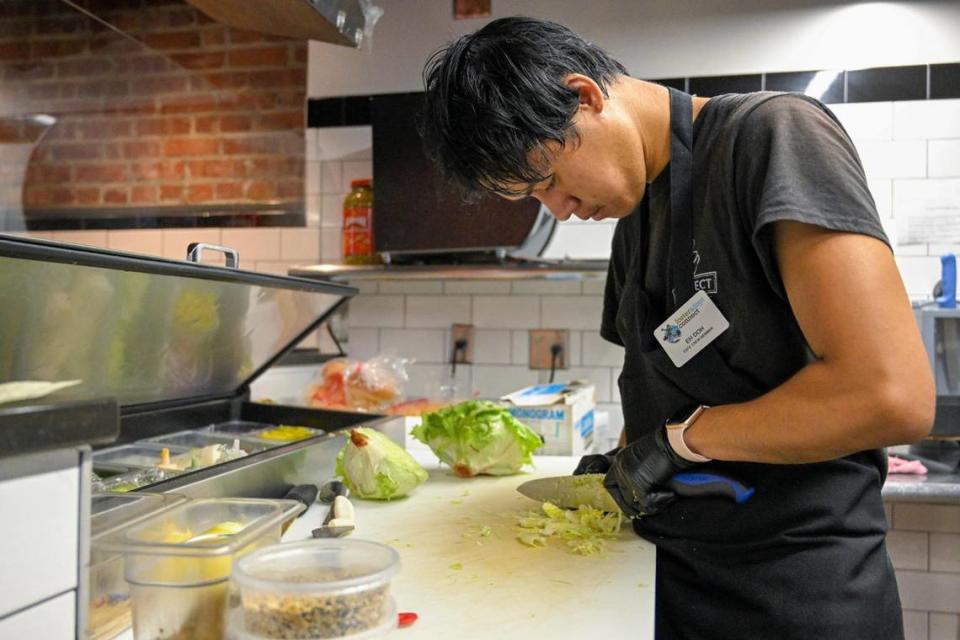 Eh Doh, 20, cut up lettuce before the lunch rush at Connect Cafe.