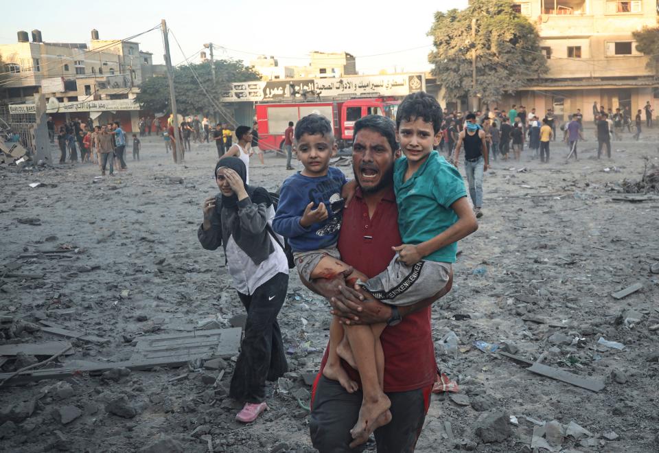 Palestinian walk away after Israeli airstrike in Rafah, Gaza Strip, Tuesday, Nov. 7, 2023.