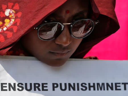 A woman holds a placard at a protest against the rape of an eight-year-old girl, in Kathua, near Jammu and a teenager in Unnao, Uttar Pradesh state, in New Delhi, India April 12, 2018. REUTERS/Cathal McNaughton