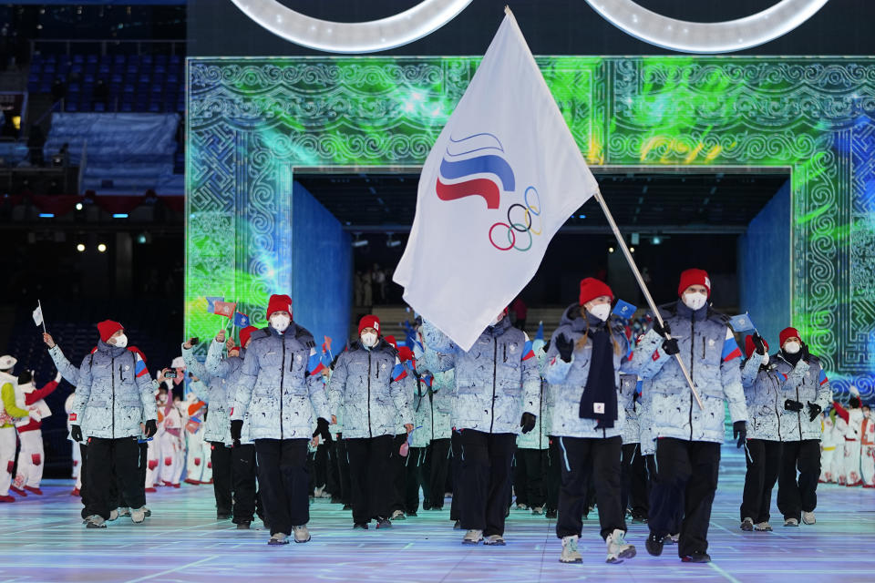 FILE - Olga Fatkulina and Vadim Shipachyov, of the Russian Olympic Committee, carry a flag into the stadium during the opening ceremony of the 2022 Winter Olympics, on Feb. 4, 2022, in Beijing. Russian athletes were competing under the acronym ROC, for Russian Olympic Committee, for the third time. One year after the invasion of Ukraine began, Russia's reintegration into the world of sports threatens to create the biggest rift in the Olympic movement since the Cold War. (AP Photo/Jae C. Hong, File)