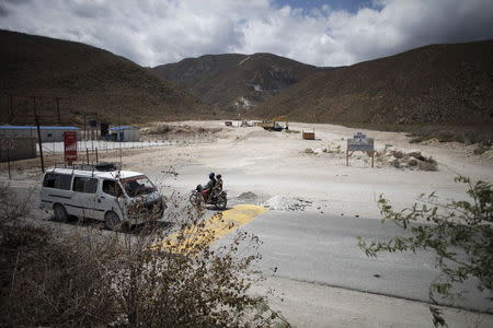 A mini bus and a motorcycle drive past the construction site of a repatriation center for returned Haitians and Haitian-Dominicans, near the border between the Dominican Republic and Haiti, in Malpasse, August 3, 2015. REUTERS/Andres Martinez Casares