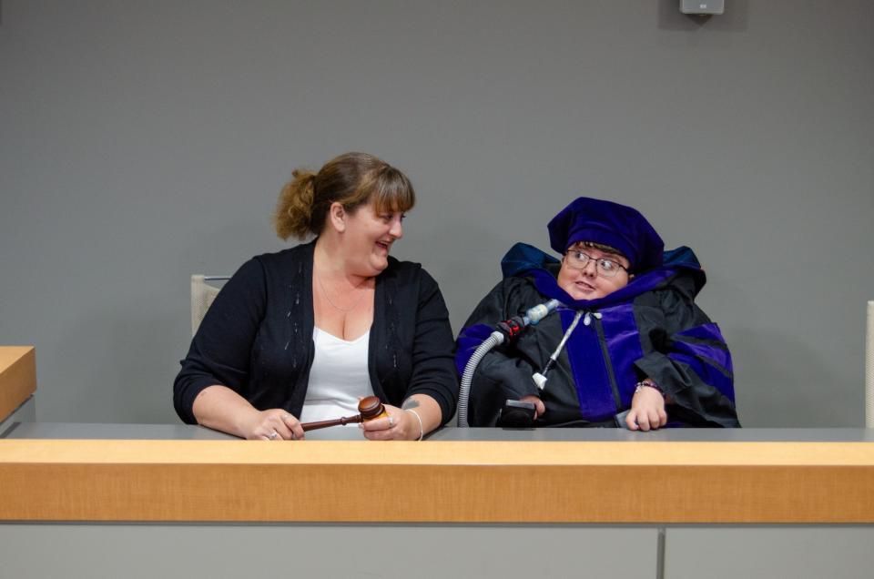 Megan Parker, right, and her mother Jaclyn Sims take a photo in the University of Akron's moot courtroom before Parker's law school graduation.