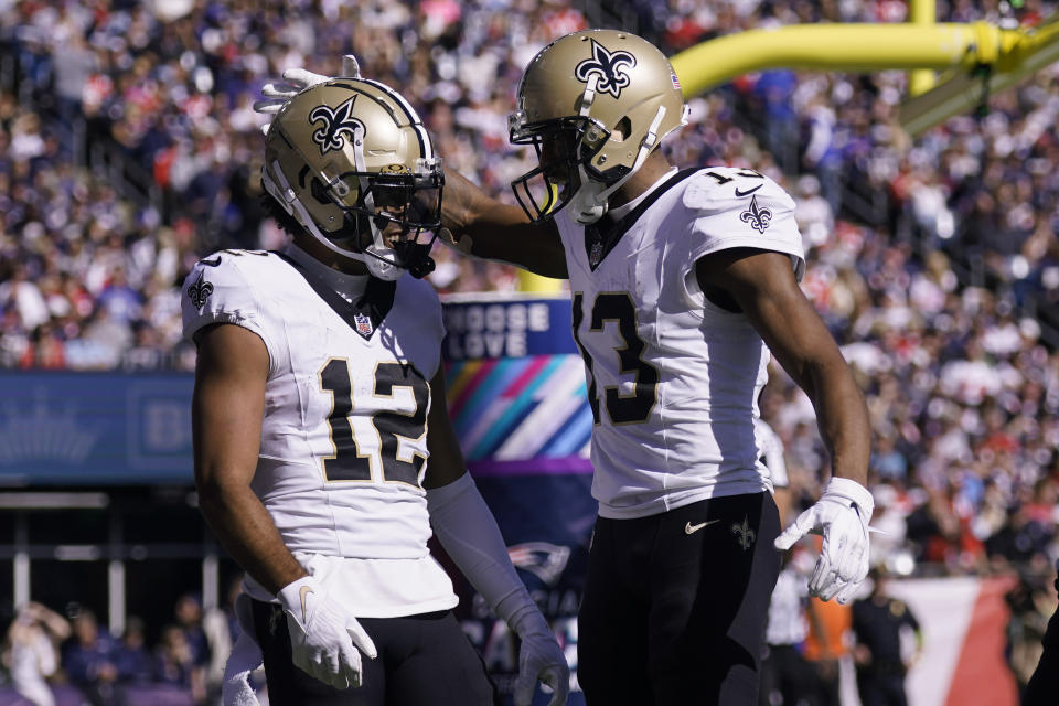 New Orleans Saints wide receiver Chris Olave (12) celebrates after his touchdown with wide receiver Michael Thomas (13) during the first half of an NFL football game against the New England Patriots, Sunday, Oct. 8, 2023, in Foxborough, Mass. (AP Photo/Charles Krupa)