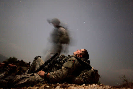 FILE PHOTO: A U.S. soldier of 2-12 Infantry 4BCT-4ID Task Force Mountain Warrior takes a break during a night mission near Honaker Miracle camp at the Pesh valley of Kunar Province, Afghanistan, August 12, 2009. REUTERS/Carlos Barria
