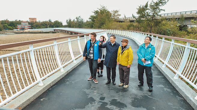 新竹縣長楊文科（右三）19日視察雙新自行車道走福興溪景觀橋，手指著前方說可看到新豐石滬群。（羅浚濱攝）