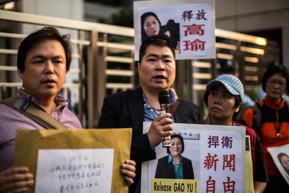 Activists hold placards as they take turns to speak outside the China liaison office during a protest in support of Chinese journalist Gao Yu in Hong Kong on April 25, 2015. A Chinese court on April 17 convicted the 71-year-old journalist of leaking state secrets and jailed her for seven years, it said, in a case seen by rights groups as part of a crackdown on government critics.   AFP PHOTO / ANTHONY WALLACE        (Photo credit should read ANTHONY WALLACE/AFP via Getty Images)