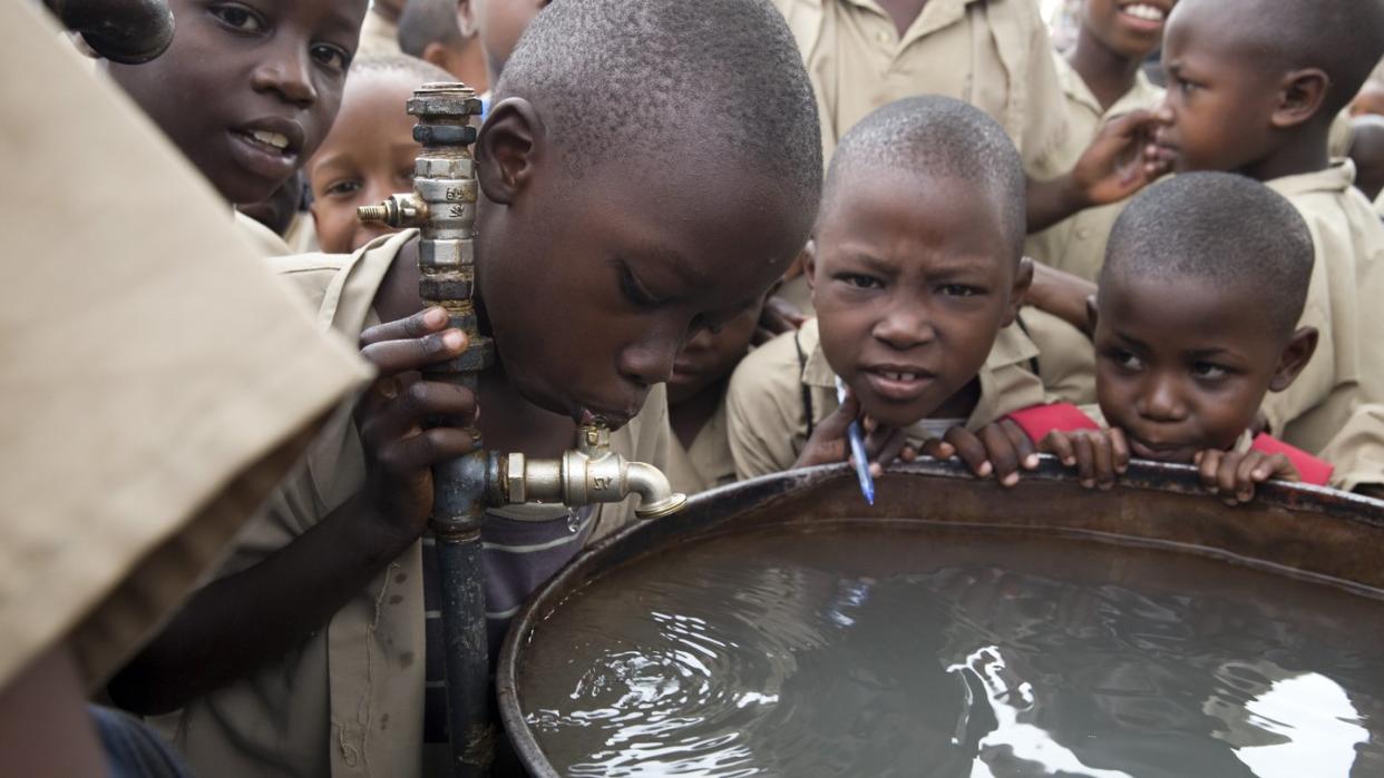 In einer Schule in Bujumbura (Brurndi) trinken Kinder an einem Wasserfass. Prognosen zufolge soll die Zahl der von Wassermangel bedrohten Personen von aktuell 3,6 Milliarden bis 2050 auf 5,7 Milliarden Menschen ansteigen. Foto: Thomas Schulze
