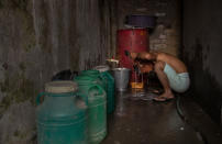 A police officer who fled Myanmar following a military coup takes a wash at an undisclosed location bordering Myanmar, in the northeastern Indian state of Mizoram, Thursday, March 18, 2021. Villagers in Mizoram have given shelter to 34 Myanmar police personnel and 1 fire fighter, who crossed over to the state over the last two weeks. Those who escaped spend their time watching local television and doing daily chores. Some of them have carried mobile phones and are trying to connect to families they were forced to leave behind. At night, all of them go to sleep on mattresses laid on the floor of a single room. (AP Photo/Anupam Nath)