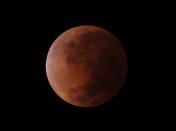 The moon is seen turning red, during a lunar eclipse over Asuncion, Paraguay,Tuesday April 15, 2014. Tuesday's eclipse is the first of four total lunar eclipses that will take place between 2014 to 2015.(AP Photo/Jorge Saenz)