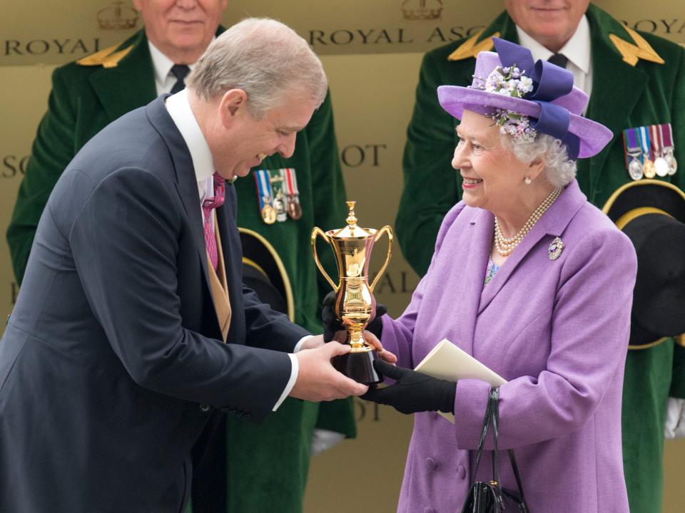 Queen Elizabeth accepts a trophy.