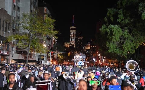 The Freedom Tower is seen in the distance as people in costumes take part in the 44rd Annual Halloween Parade in New York  - Credit: AFP
