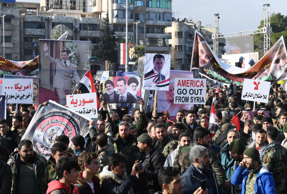 Syrian demonstrators wave portraits of Iran's Supreme Leader Ayatollah Ali Khamenei (C), Syrian President Bashar al-Assad and head of Hezbollah Hassan Nasrallah, in the central Saadallah al-Jabiri square in the northern Syrian city of Aleppo on January 7, 2020, to mourn and condemn the death of Iranian military commander Qasem Soleimani, and nine others in a US air strike in Baghdad. (Photo by - / AFP) (Photo by -/AFP via Getty Images)