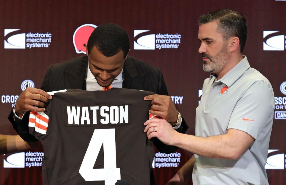 Cleveland Browns quarterback Deshaun Watson, left, admires the nameplate on his new jersey as head coach Kevin Stefanski looks on during Watson's introductory press conference at the Cleveland Browns Training Facility in Berea.