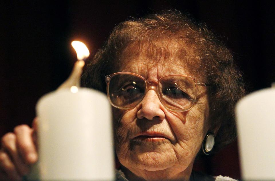 Auschwitz's survivor Lea Novera lights a candle while attending a ceremony during the International Holocaust Remembrance Day at the AMIA Jewish cultural centre in Buenos Aires