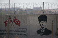 A graffiti of modern Turkey's founder Mustafa Kemal Ataturk is seen on the Turkish side of the border between Turkey and Syria, in Akcakale, Sanliurfa province, southeastern Turkey, Tuesday, Oct. 8, 2019. Turkey's vice president Fuat Oktay says his country won't bow to threats in an apparent response to U.S. President Donald Trump's warning to Ankara about the scope of its planned military incursion into Syria.(AP Photo/Lefteris Pitarakis)