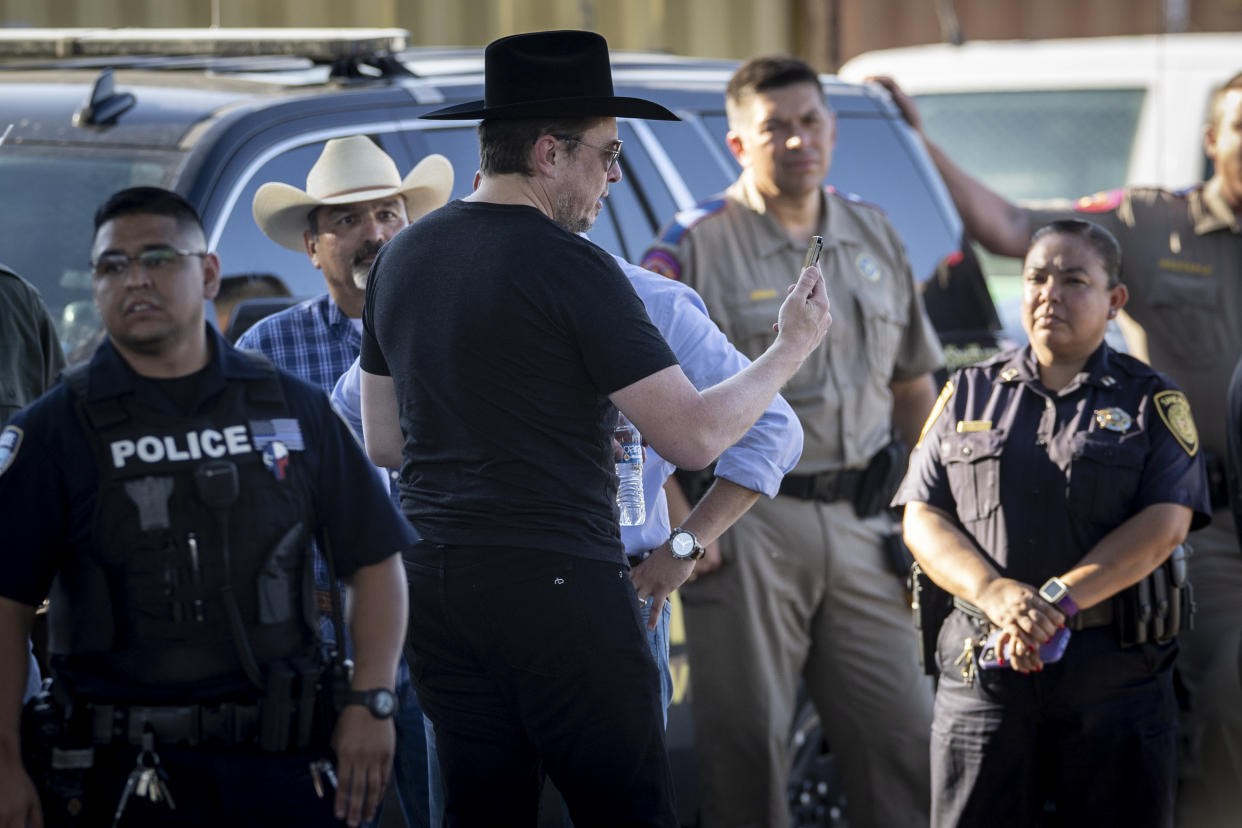 El empresario tecnológico Elon Musk, con un sombrero Stetson negro, transmite en vivo mientras visita la frontera entre Texas y México el 28 de septiembre de 2023 en Eagle Pass, Texas. Musk recorrió la frontera a lo largo de la orilla del Río Grande con el representante Tony Gonzales (R-Texas) para ver de primera mano la actual crisis migratoria, que ha calificado de 