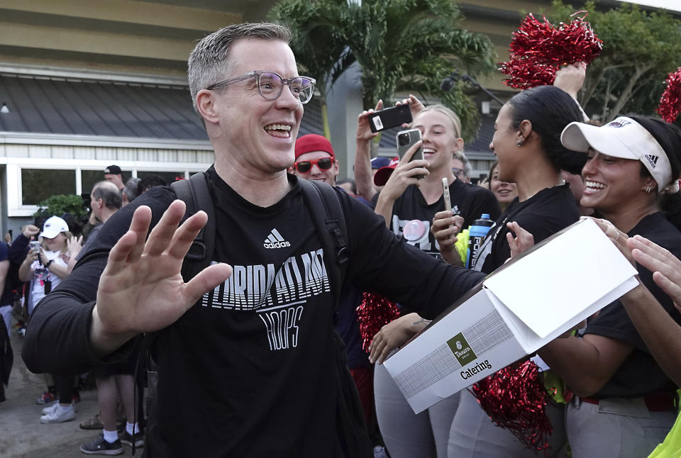 Florida Atlantic University men's NCAA college basketball coach Dusty May is greeted by fans as the team leaves the campus, Wednesday, March 29, 2023, in Boca Raton, Fla. The school that used to be known for coaches looking to rebound now has a team headed to the Final Four, led by a coach whose claim to fame when he entered coaching was that he was a student manager for Bob Knight at Indiana. (Joe Cavaretta/South Florida Sun-Sentinel via AP)