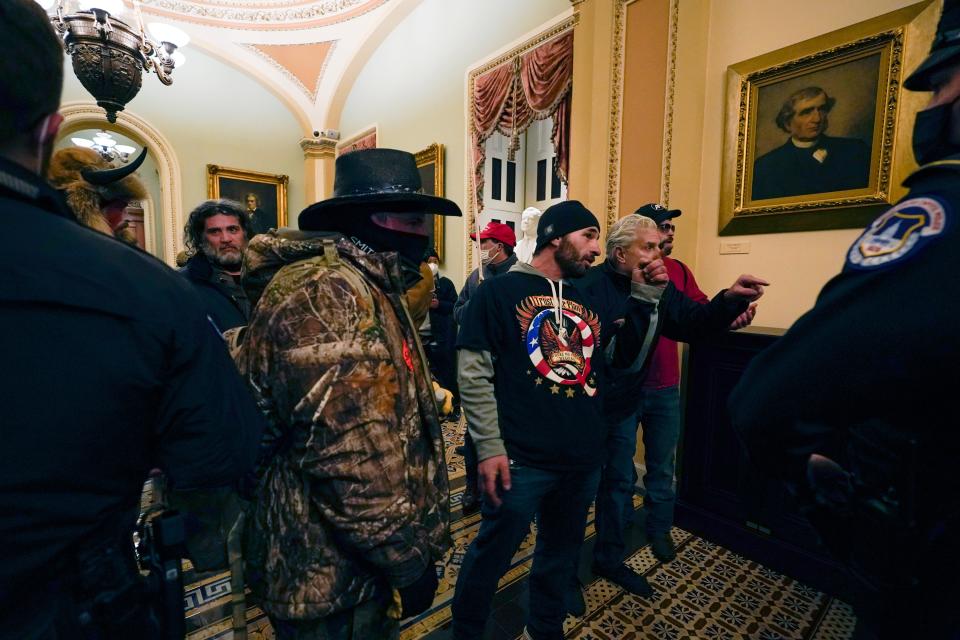 Doug Jensen (C), 41, of Des Moines and other Pro-Trump rioters confront U.S. Capitol Police officers in a hallway near the Senate chamber at the Capitol in Washington, Wednesday, Jan. 6, 2021.  Jensen was arrested by the FBI at 1 a.m. on Saturday, Jan. 9, 2021.