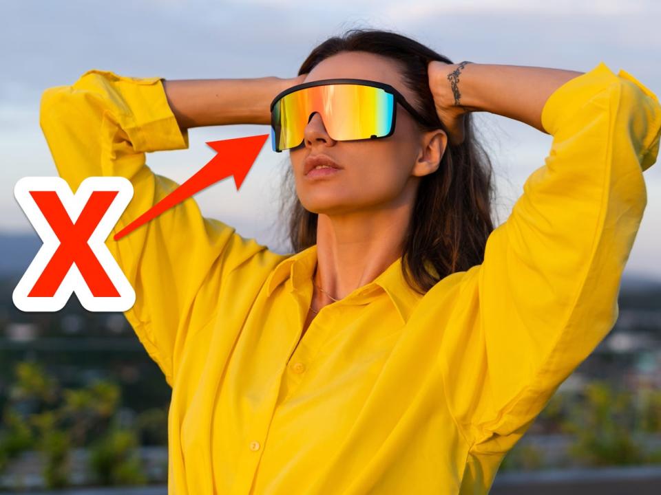 red x and arrow pointing at person wearing colorful shield sunglasses and a yellow shirt