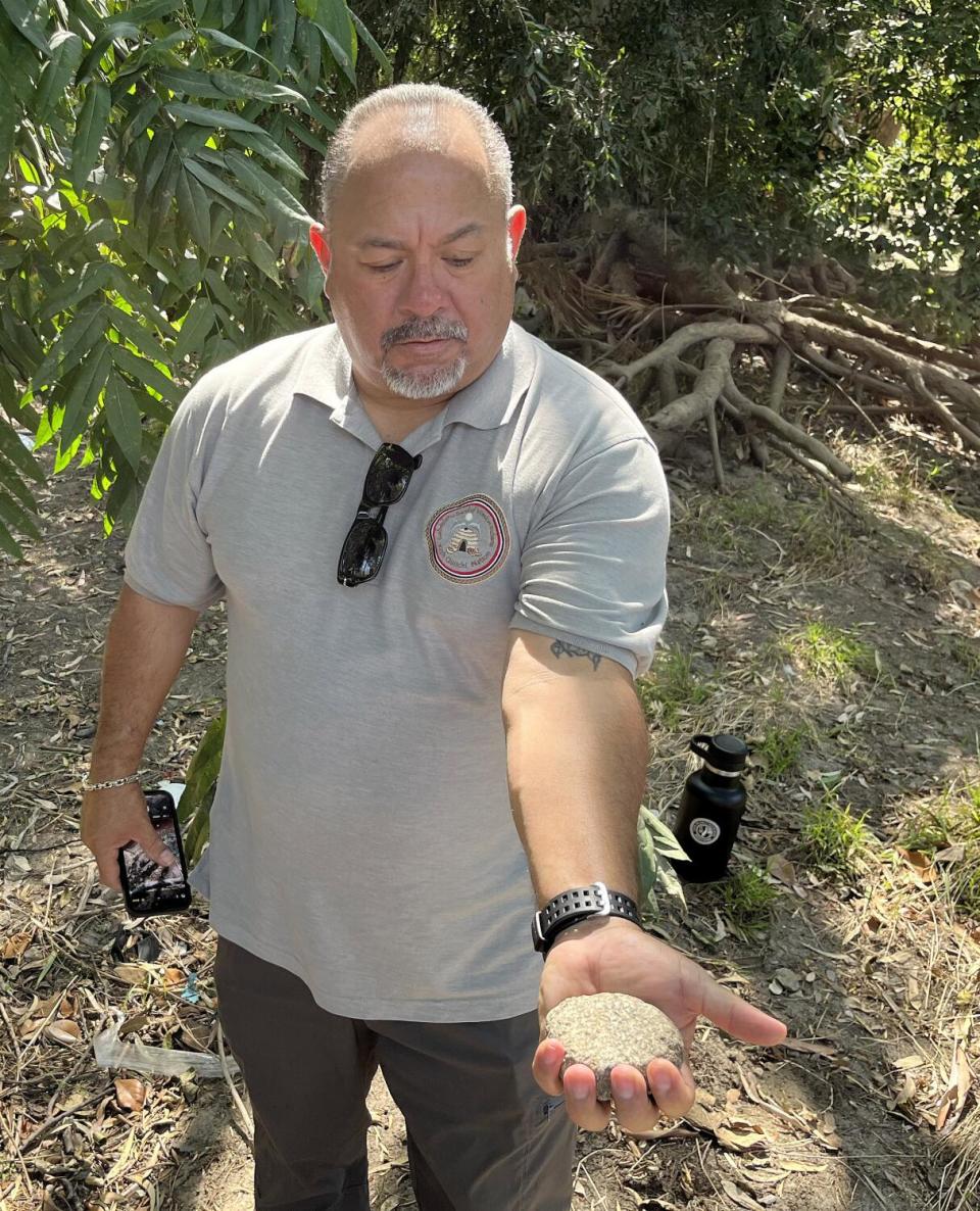 A man holds a rounded stone.