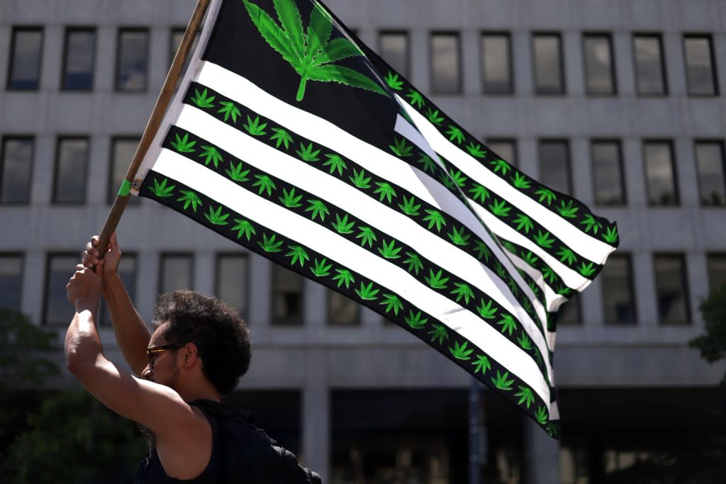 A marijuana activist holds a flag during a march on Independence Day on July 4, 2021 in Washington, DC. (Photo by Alex Wong/Getty Images)