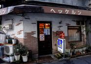 Shizuo Mori, the owner of Heckeln coffee shop is seen through a window of a door while he brews coffee at his shop in Tokyo