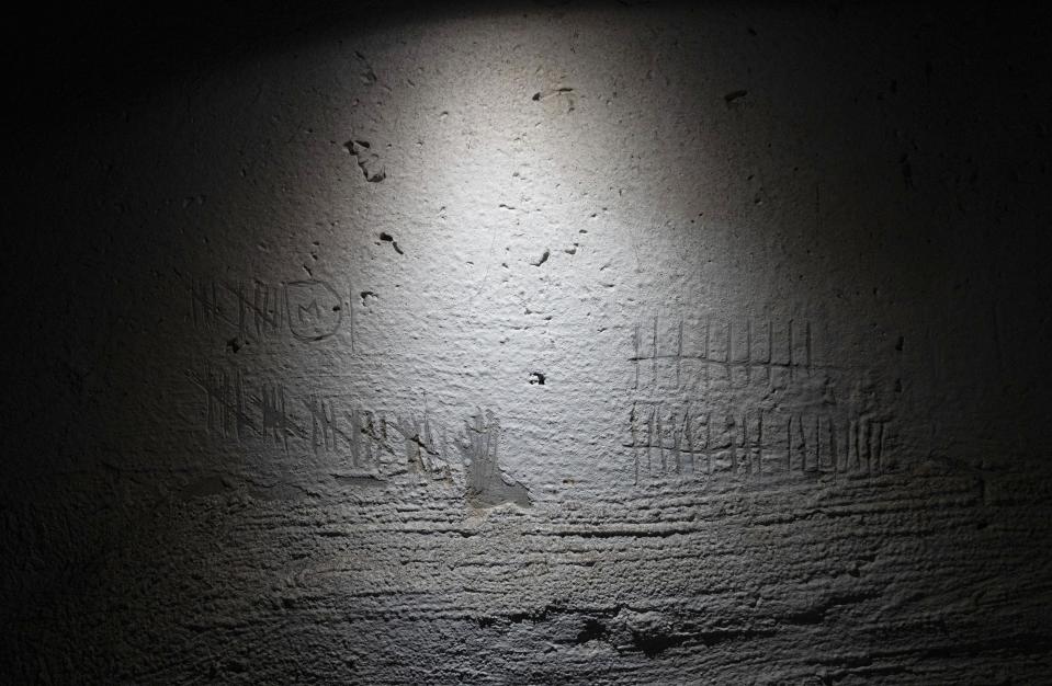 FILE - Tally marks are etched in to a wall by detainees to keep track of time in a building used, according to a war crimes prosecutor, by Russian forces as a place of torture in Kherson, Ukraine, Dec. 8, 2022. In a deliberate, widespread campaign, Russian forces systematically targeted influential Ukrainians, nationally and locally, to neutralize resistance through detention, torture and executions, an Associated Press investigation has found. (AP Photo/Evgeniy Maloletka, File)