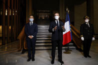 French President Emmanuel Macron, center, delivers a speech while Interior Minister Gerald Darmanin, left, and Seine-Saint-Denis prefect Georges-Francois Leclerc listen, after a visit on the fight against separatism at the Seine Saint Denis prefecture headquarters in Bobigny, a northeastern suburbs of Paris, Tuesday Oct. 20, 2020. Authorities were looking into about 50 associations suspected of encouraging hate speech and the issue will be discussed at a Cabinet meeting Wednesday after the history teacher Samuel Paty was beheaded on Friday by an 18-year-old Moscow-born Chechen refugee. (Ludovic Marin, Pool via AP)