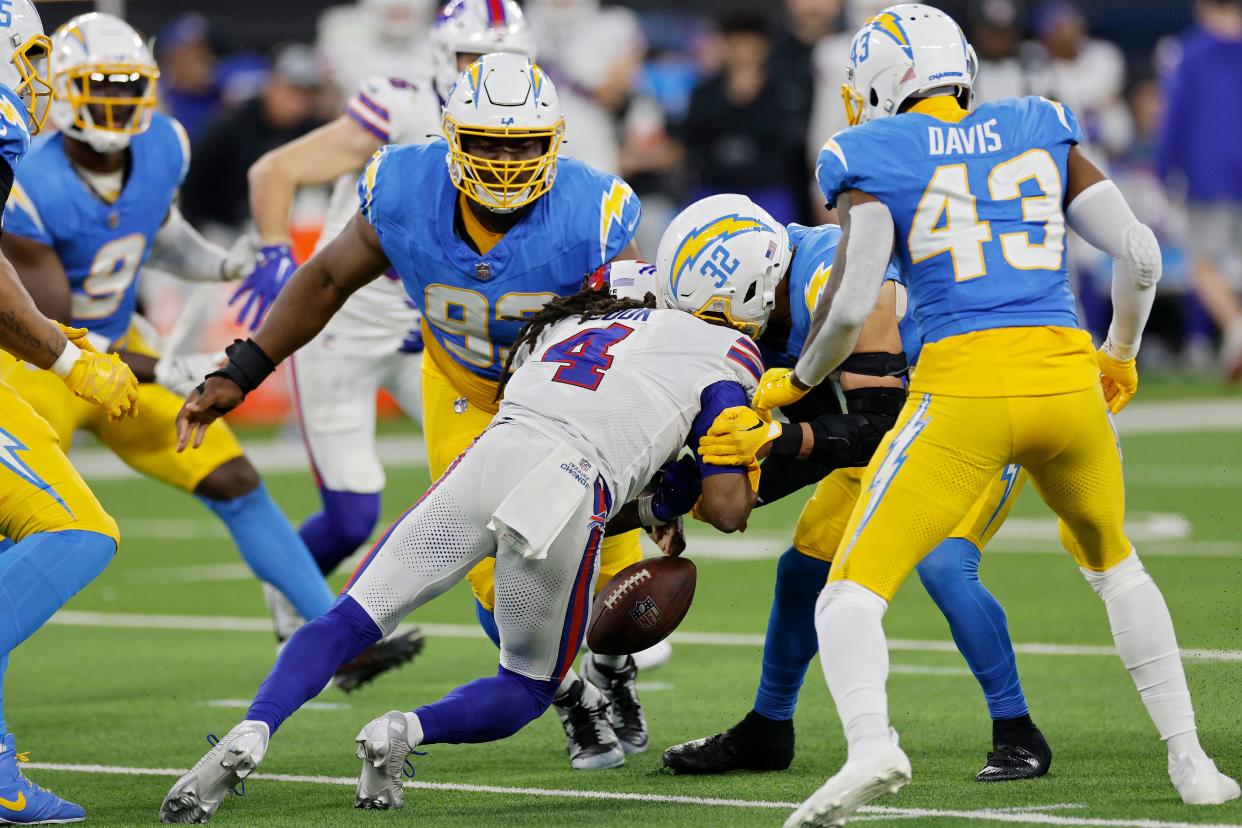 INGLEWOOD, CALIFORNIA - DECEMBER 23: Alohi Gilman #32 of the Los Angeles Chargers forces a fumble by James Cook #4 of the Buffalo Bills in the fourth quarter at SoFi Stadium on December 23, 2023 in Inglewood, California. (Photo by Kevork Djansezian/Getty Images)