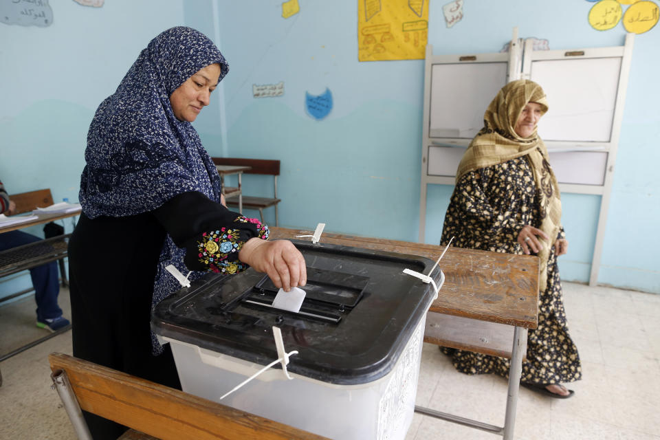 A voter casts her ballot on constitutional amendments during the second day of three-day voting at polling station in Cairo, Egypt, Sunday, April 21, 2019. Egyptians are voting on constitutional amendments that would allow President Abdel-Fattah el-Sissi to stay in power until 2030.(AP Photo/Amr Nabil)