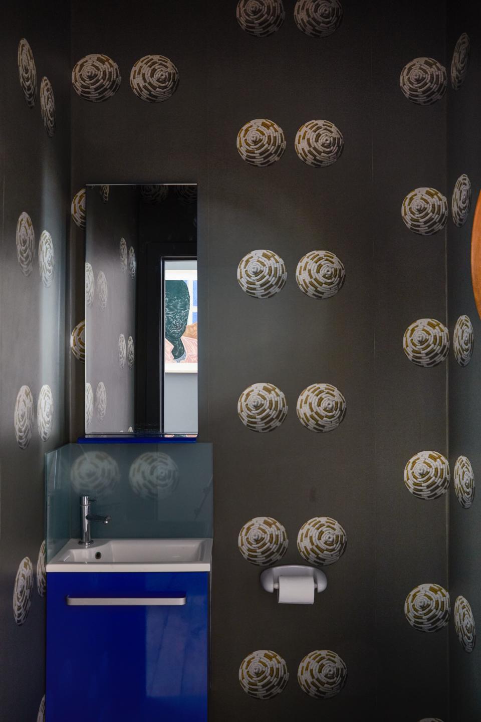 Tovey has had the guest bathroom papered in a playful design created by English artist Sarah Lucas, from the Whitechapel Gallery. Artwork reflected in mirror by Toyin Ojih Odutola.