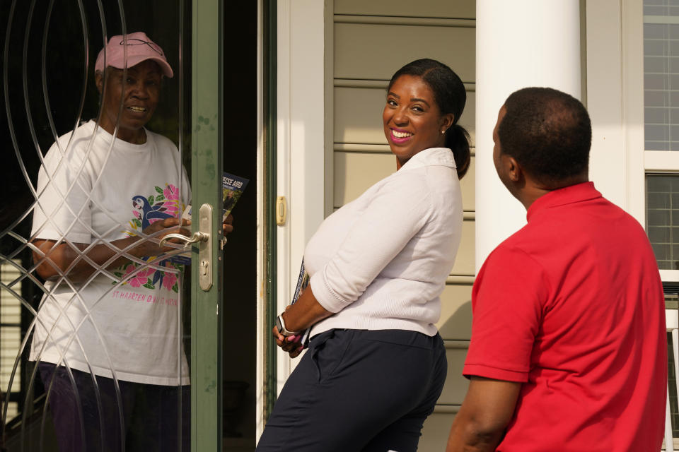 Former Delegate Lashrecse Aird, center, talks with a constituent along with Henrico County supervisor, Tyrone Nelson, right, as they canvas a neighborhood, Monday, May 22, 2023, in Henrico County, Va. Aird is challenging State Sen. Joe Morrissey in a Democratic primary for a newly redrawn senatorial district. (AP Photo/Steve Helber)