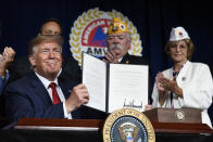 President Donald Trump holds up a presidential memorandum that he signed that discharges the federal student loan debt of totally and permanently disabled veterans following his speech at the American Veterans (AMVETS) 75th National Convention in Louisville, Ky., Wednesday, Aug. 21, 2019. (AP Photo/Susan Walsh)