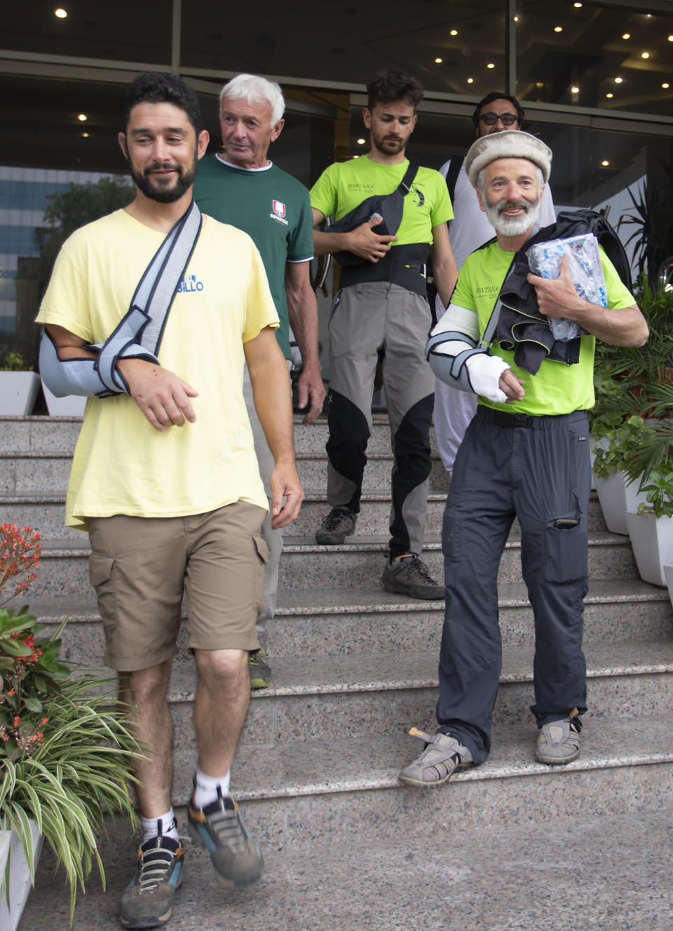 The team leader, Tarcisio Bellò, 57, right, leaves a hotel with his colleagues to see the Italian ambassador in Islamabad, Pakistan, Thursday, June 20, 2019. The renowned Italian mountaineer, who narrowly survived along-with six other members of an expedition on a mountain, burst into tears Thursday when he recalled how helplessly he saw one of his Pakistani colleagues being swept away by an avalanche that struck them at an altitude of around 5,300 meters (17,390 feet) earlier this week. (AP Photo/B.K. Bangash)
