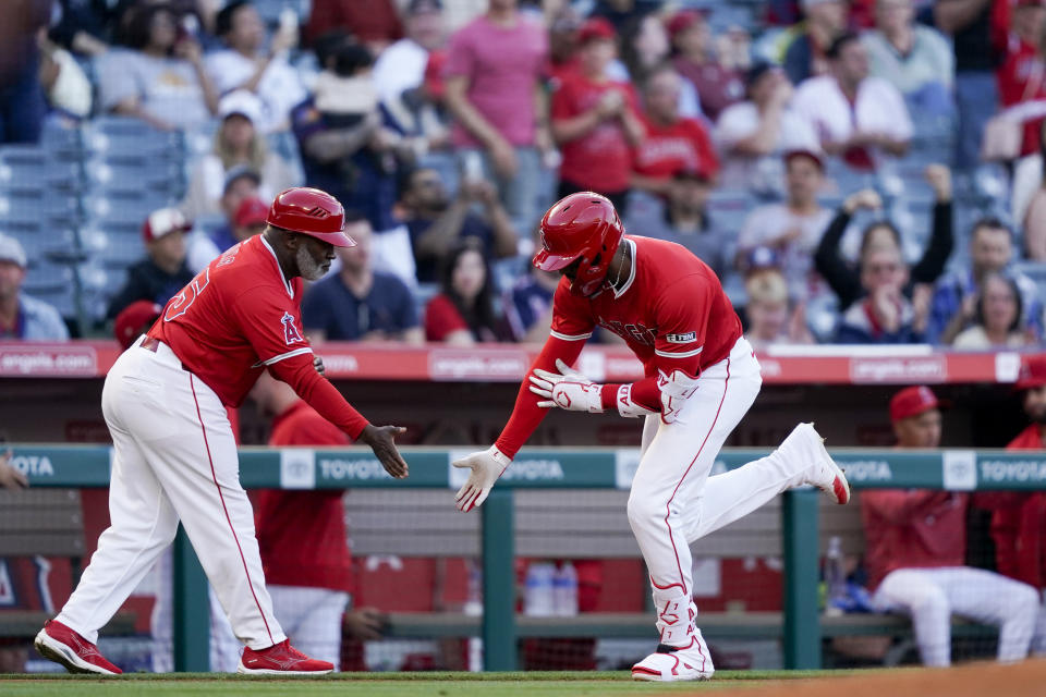 Los Angeles Angels' Jo Adell, right, celebrates after his solo home run with third base coach Eric Young Sr., left, during the first inning of a baseball game against the Philadelphia Phillies, Monday, April 29, 2024, in Anaheim, Calif. (AP Photo/Ryan Sun)