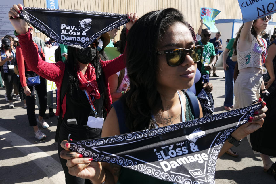 FILE - Demonstrators hold bandanas that read "pay up for loss & damage" at the COP27 U.N. Climate Summit, Nov. 12, 2022, in Sharm el-Sheikh, Egypt. (AP Photo/Peter Dejong, File)