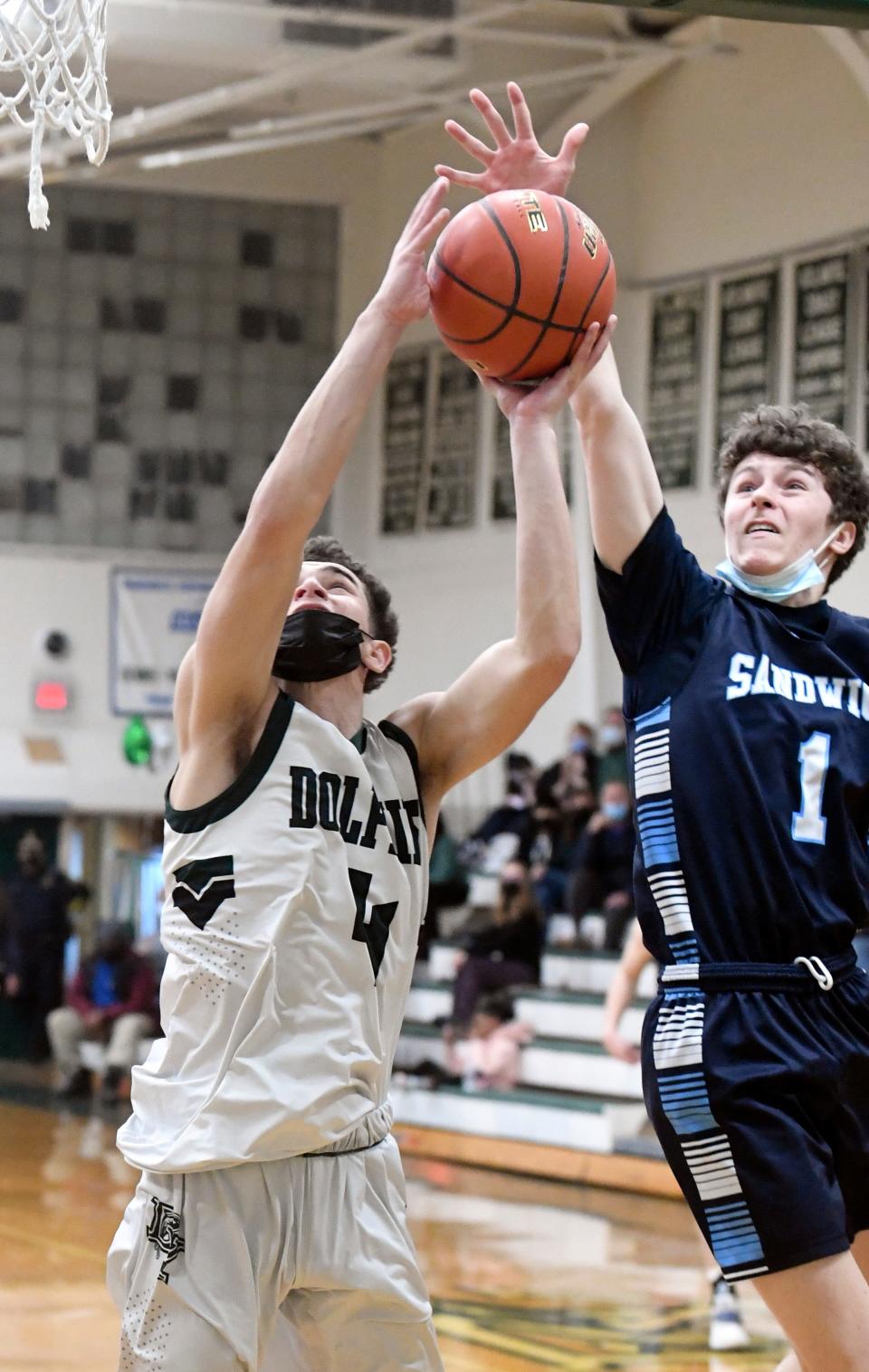 Connor Finn of Sandwich blocks a shot by Jason Villani of Dennis-Yarmouth in this February 2022 game.
