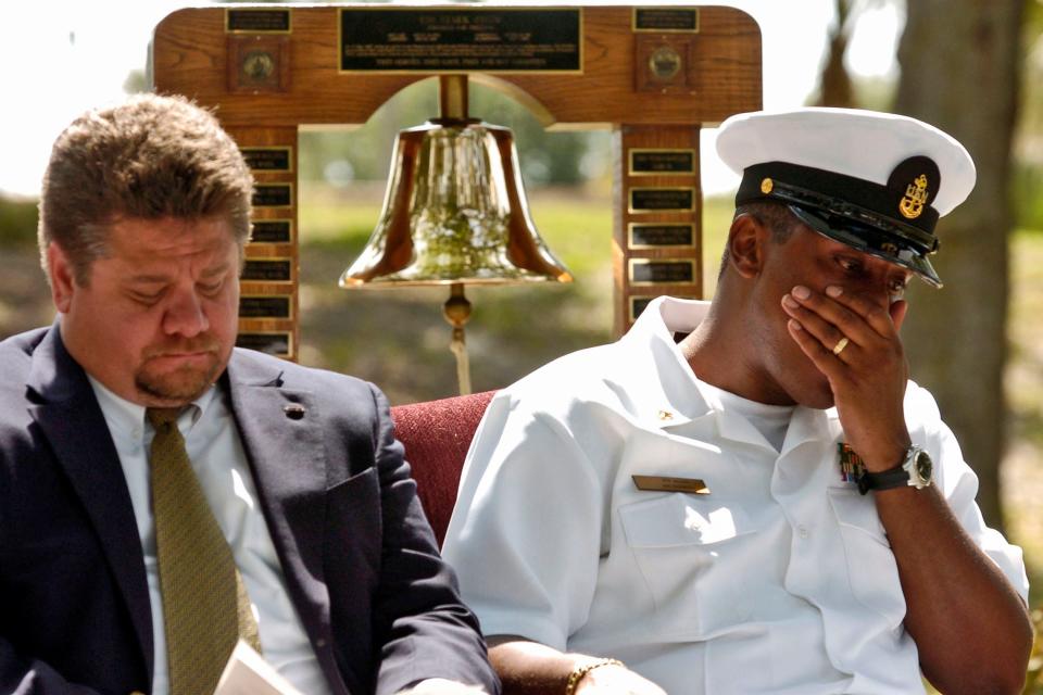 At a 2005 memorial to the 37 sailors killed aboard the USS Stark, Chief Petty Officer Darryl Allen (on the right) composes himself after delivering a tribute to the crew. He was a Stark crew member along with Tim Martineau, sitting next to him, who had earlier read a scripture passage in honor of his fallen shipmates.