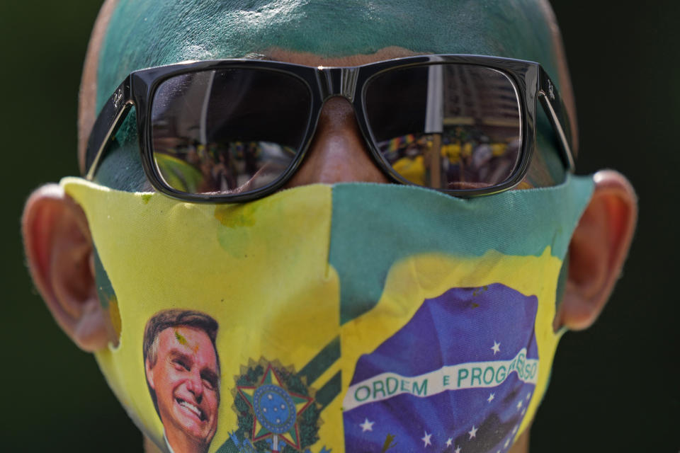 A supporter of Brazilian President Jair Bolsonaro wears a face mask, due to the COVID-19 pandemic, decorated with a photo of Bolsonaro at a rally marking Independence Day in Sao Paulo, Brazil, Tuesday, Sept. 7, 2021. (AP Photo/Andre Penner)