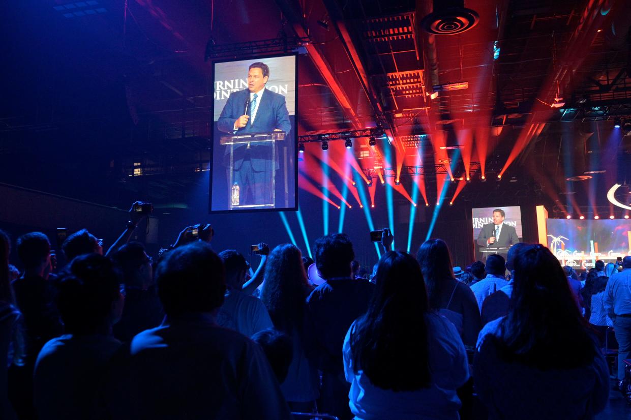 Attendees make photographs of Florida Gov. Ron DeSantis as he speaks during the Turning Point USA Student Action Summit, Friday, July 22, 2022, in Tampa, Fla. (AP Photo/Phelan M. Ebenhack)