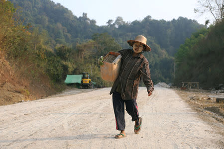 A road builder carries sand on the unpaved road in Thandwe, Rakhine State, Myanmar February 19, 2019. REUTERS/Ann Wang